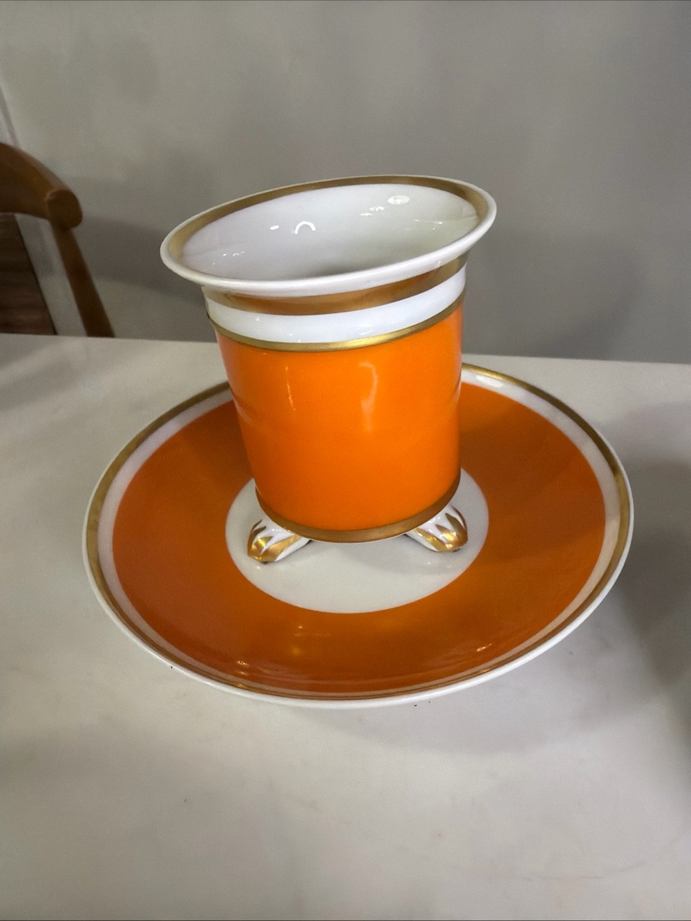 Limoges France 3 legged cup with saucer, orange and gold
